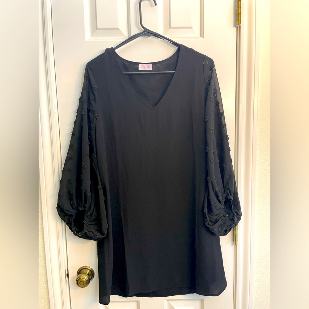 Black pink lily cocktail dress with sheer sleeves.